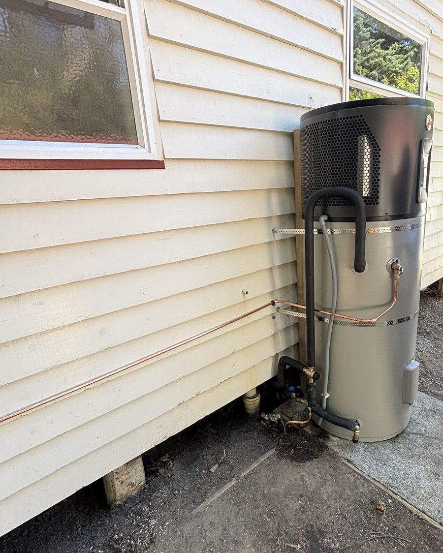Hot water heat pump installed beside a weatherboard home